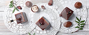 Chocolate souffle candy dessert with chocolate praline and cocoa beans on wooden background close up.