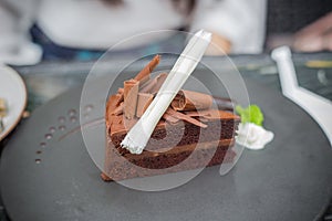 Chocolate sponge cake with chocolate buttercream frosting and role brown white chocolate on top