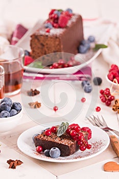 Chocolate sponge cake with fresh fruit on white dish