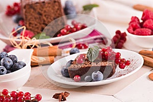 Chocolate sponge cake with fresh fruit on white dish