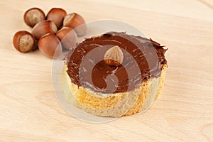 Chocolate spread with whole hazelnuts on slice of baguette