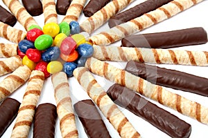 Chocolate sticks with a cream and the multi-coloured sweets isol