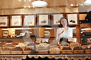Chocolate Store. Female Seller In Confectionery Shop.