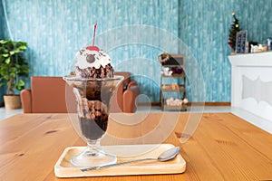 Chocolate sundae ice cream served with whipping cream and cherry