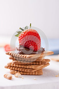 Chocolate sweet melting nougat cream on cookies with strawberries