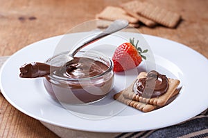 Chocolate sweet melting nougat cream on cookies with strawberries