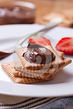 Chocolate sweet melting nougat cream on cookies with strawberries