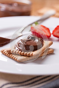 Chocolate sweet melting nougat cream on cookies with strawberries