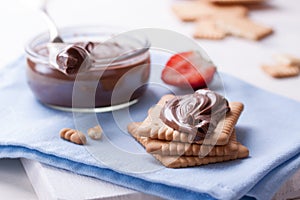 Chocolate sweet melting nougat cream on cookies with strawberries