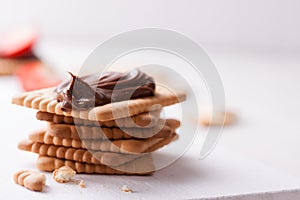 Chocolate sweet melting nougat cream on cookies with strawberries