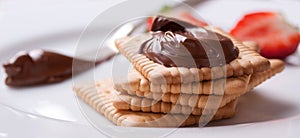 Chocolate sweet melting nougat cream on cookies with strawberries