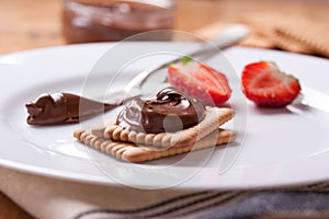 Chocolate sweet melting nougat cream on cookies with strawberries