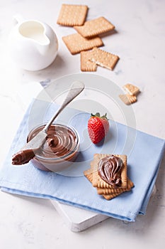 Chocolate sweet melting nougat cream on cookies with strawberries