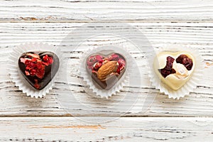 chocolate sweets in the form of a heart with fruits and nuts on a colored background. top view with space for text