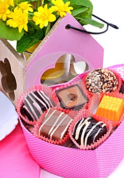 Chocolate sweets in gift boxes, yellow wildflowers