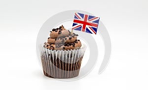 Chocolate swirl cupcake with a British Union Jack flag toothpick in it isolated on white