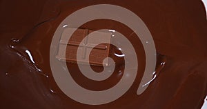 Chocolate tablet falling into milk chocolate