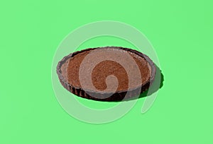 Chocolate tart in bright light isolated on a green background