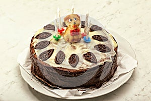 Chocolate tart with ornaments and little brown puppy marchpane figure with six candles