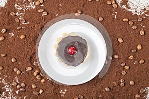 Chocolate tartalette in a white plate on the blended coffee powder