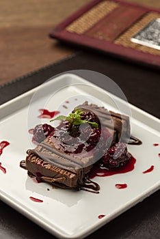 Chocolate terrine cake piece with raspberry syrup