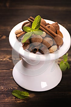 Chocolate truffle candies and assortment of nuts on white stand