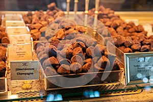 Chocolate truffles bites covered with cocoa a lot on shop window. Heap of chocolate truffle, assorted chocolates. Candy balls of