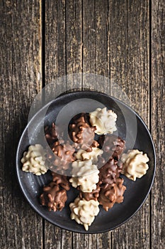 Chocolate truffles. Sweer pralines on plate on wooden table