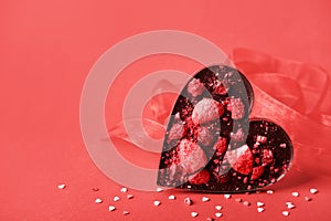 Chocolate valentine heart. Handmade chocolate with freeze-dried berries. Love symbol on red background