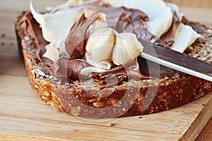 Chocolate and vanilla creamy spread on brown whole wheat bread slice