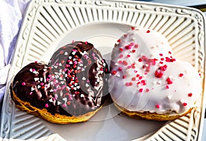 Chocolate and vanilla heart donut with tiny red heart sprinkles on top