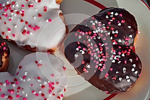 Chocolate and vanilla heart donut with tiny red heart sprinkles on top