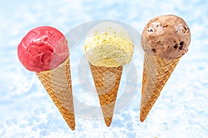 Chocolate, vanilla and strawberry Ice cream in the cone on white background