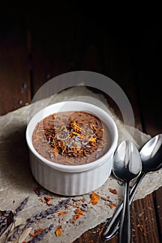 Chocolate vegan dessert - aquafaba mousse - egg free, non-dairy cocoa souffle with lavender flower petal on dark moody background