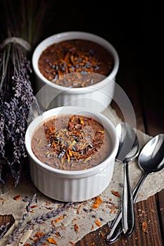 Chocolate vegan dessert - aquafaba mousse - egg free, non-dairy cocoa souffle with lavender flower petal on dark moody background