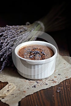 Chocolate vegan dessert - aquafaba mousse - egg free, non-dairy cocoa souffle with lavender flower petal on dark moody background