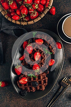 Chocolate waffles with milk and berries for breakfast. Chocolate cookies amerikaner shaped waffles photo