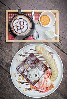 Chocolate waffles with vanilla ice cream, banana, whipped cream