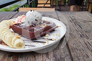 Chocolate waffles with vanilla ice cream, banana, whipped cream