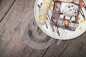 Chocolate waffles with vanilla ice cream, banana, whipped cream