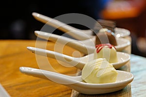 Chocolate in white spoons for testing wine