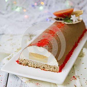 Chocolate yule log christmas cake, also know as Buche de Noel, with tangerine mousse decorated with persimmon, orange photo