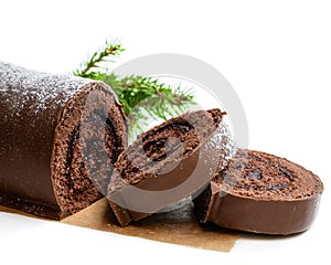 Chocolate yule log christmas cake coated with milk chocolate isolated on white