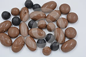 Chocolates, peanuts, nuts, raisins covered with chocolate glaze, milk and dark chocolate pebbles.