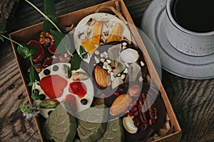 Chocolates with dried fruits in a box and a cup of coffee