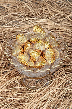 Chocolates wrapped in foil in luxury candy. Chocolate candies in a box in a gold wrapper