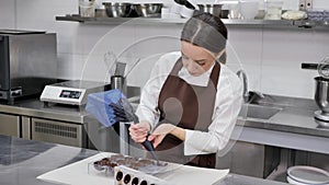 Chocolatier pours the chocolate into the molds. Pastry bag chef fills the hot melted chocolate into a silicone mold