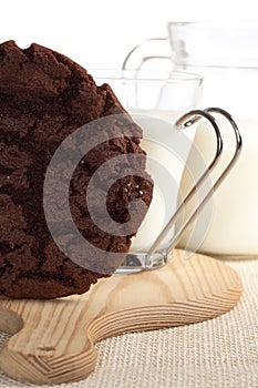 Chocolaty cookie and some milk on background