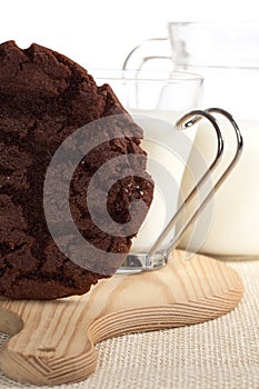 Chocolaty cookie and some milk on background photo