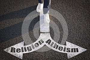 Choice between atheism and religion. Man walking towards drawn marks on road, closeup. Arrows with words pointing in opposite